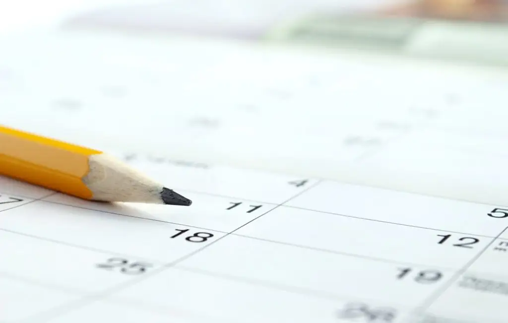 a pencil sitting on top of a close up view of a calendar