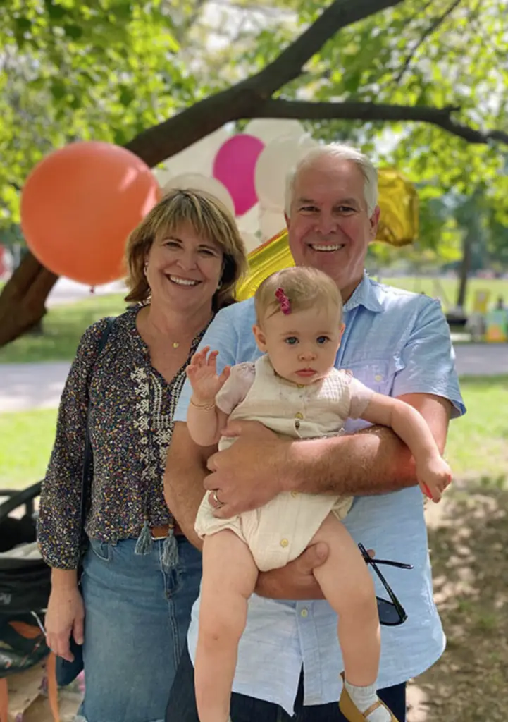 Annie Gallagher and her husband holding their young granddaughter showing the importance of transmitting a faith heritage