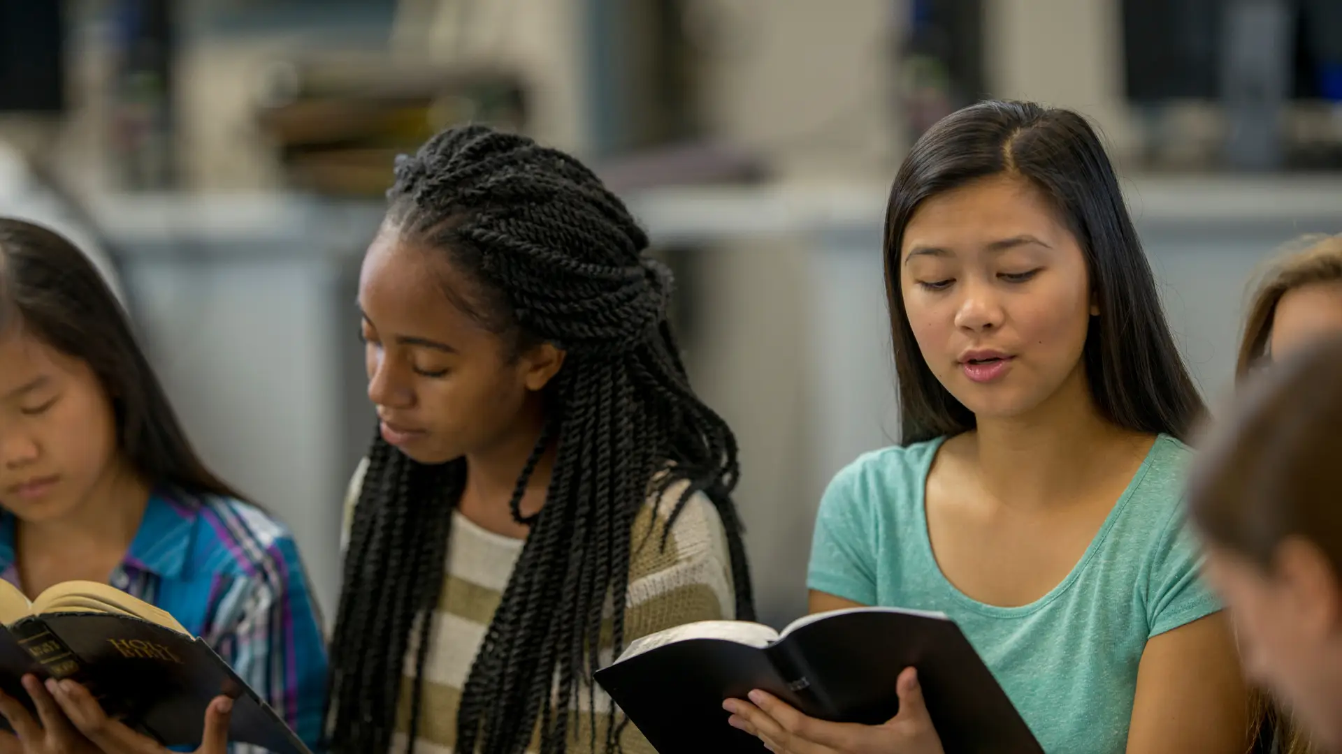 Teenage students studying the bible together fostering biblical thinking by kids