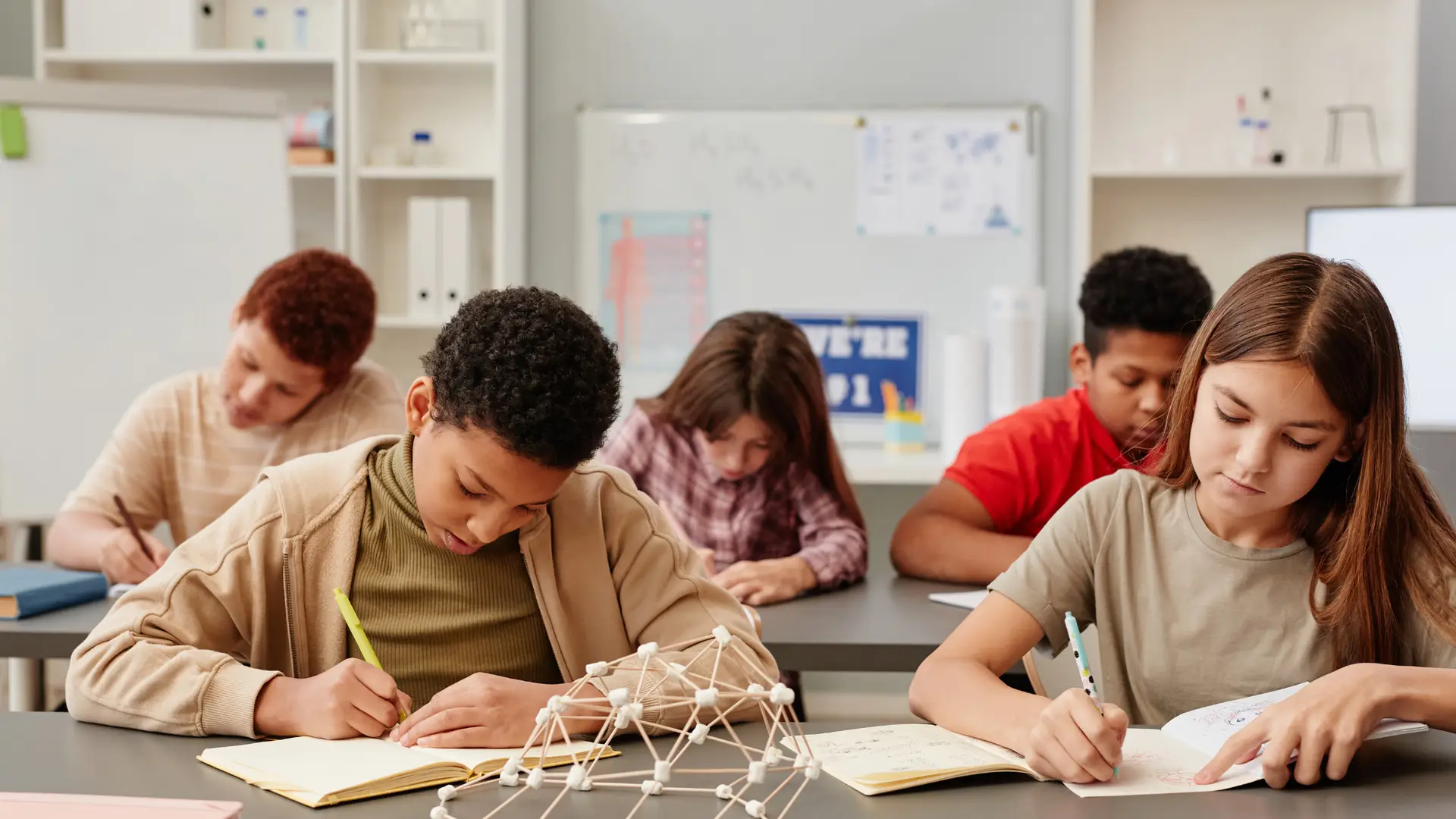 students studying biblical integration in science class with notes and a molecule figure on desk