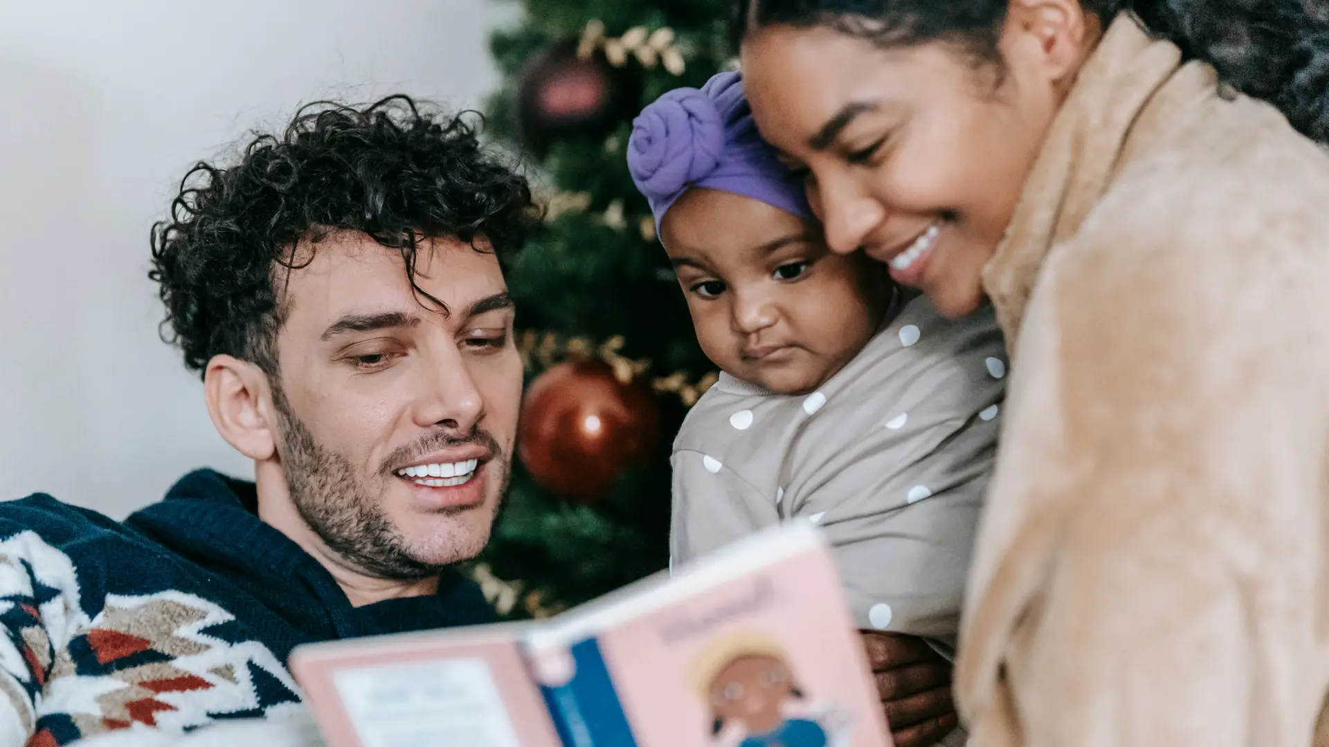 parents reading a book with their child to aid in fostering a child's relationship with Jesus at Christmastime